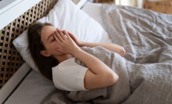 Mujer con insomnio acostada en la cama